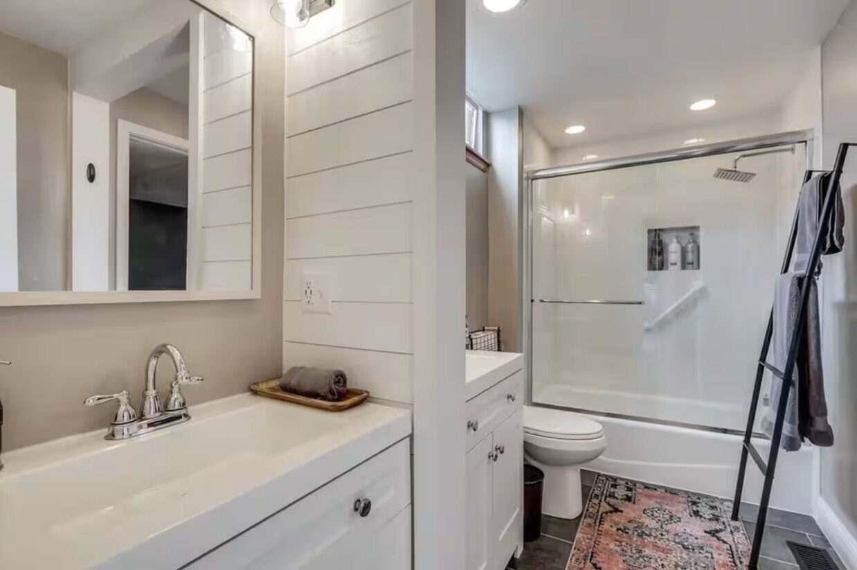 Bathroom with shiplap accent wall and glass shower