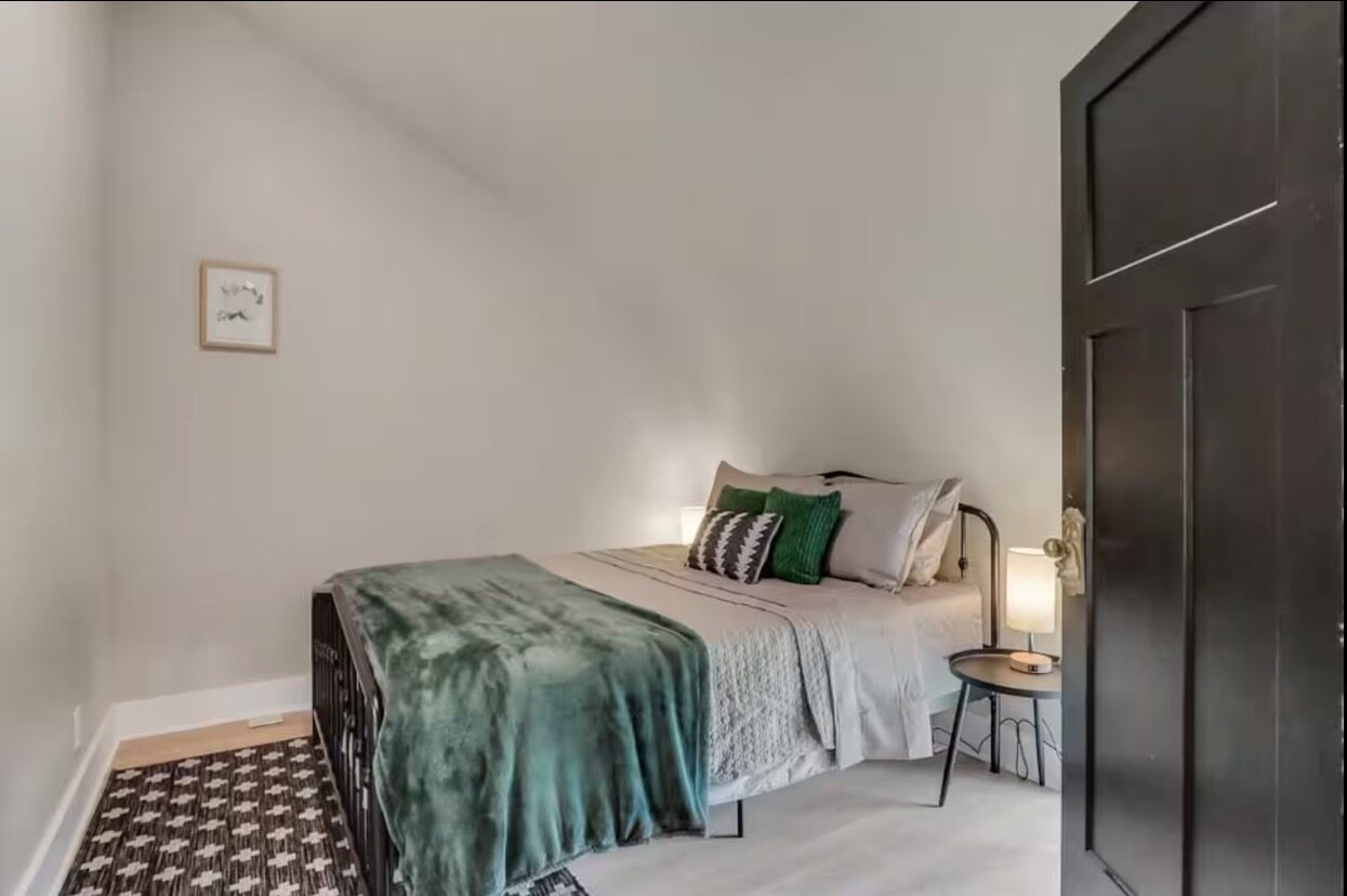 Third bedroom with cozy green throw
