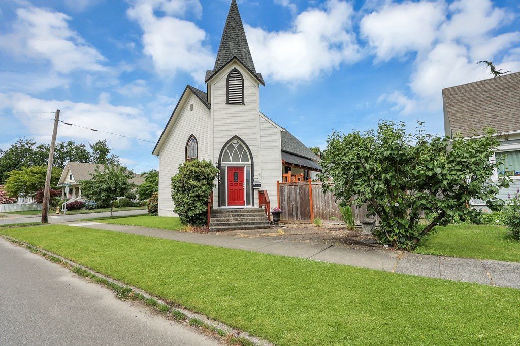 Front exterior of the Enumclaw Church House with steeple and red door