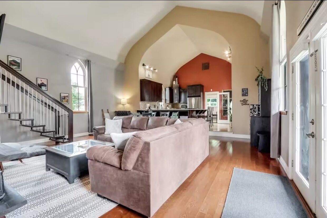 Living room with red accent arch opening to the dining area
