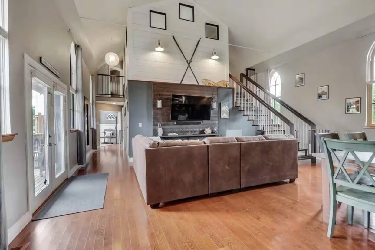 Open living room with vaulted ceiling and arched windows